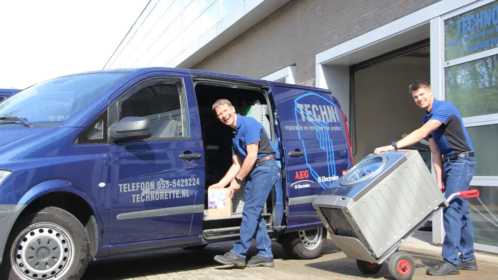 Monteurs van Technorette laden een wasmachine in de servicebus